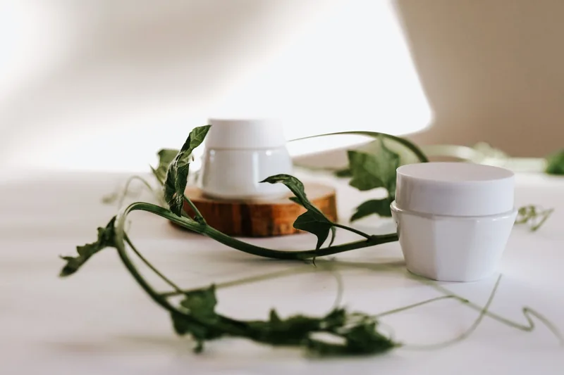 Two white jars with a trailing vine. Illustrative stock photograph, not the product.